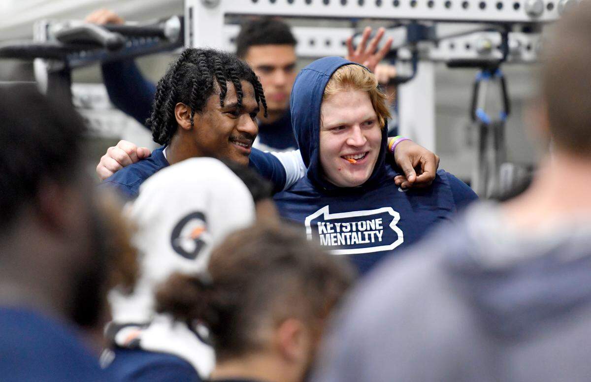 Penn State’s Curtis Jacobs and Jordan van den Berg cheer on a teammate during a weight lifting session on Thursday, March 3, 2022.