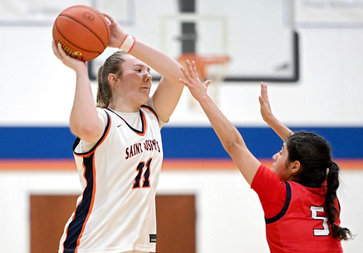 Saint Joseph’s Catholic Academy’s Aubrey Yartz looks for an open teammate over a Juniata defender during the game on Thursday, Jan. 23, 2025. Saint Joseph’s Catholic Academy won, 72-34.