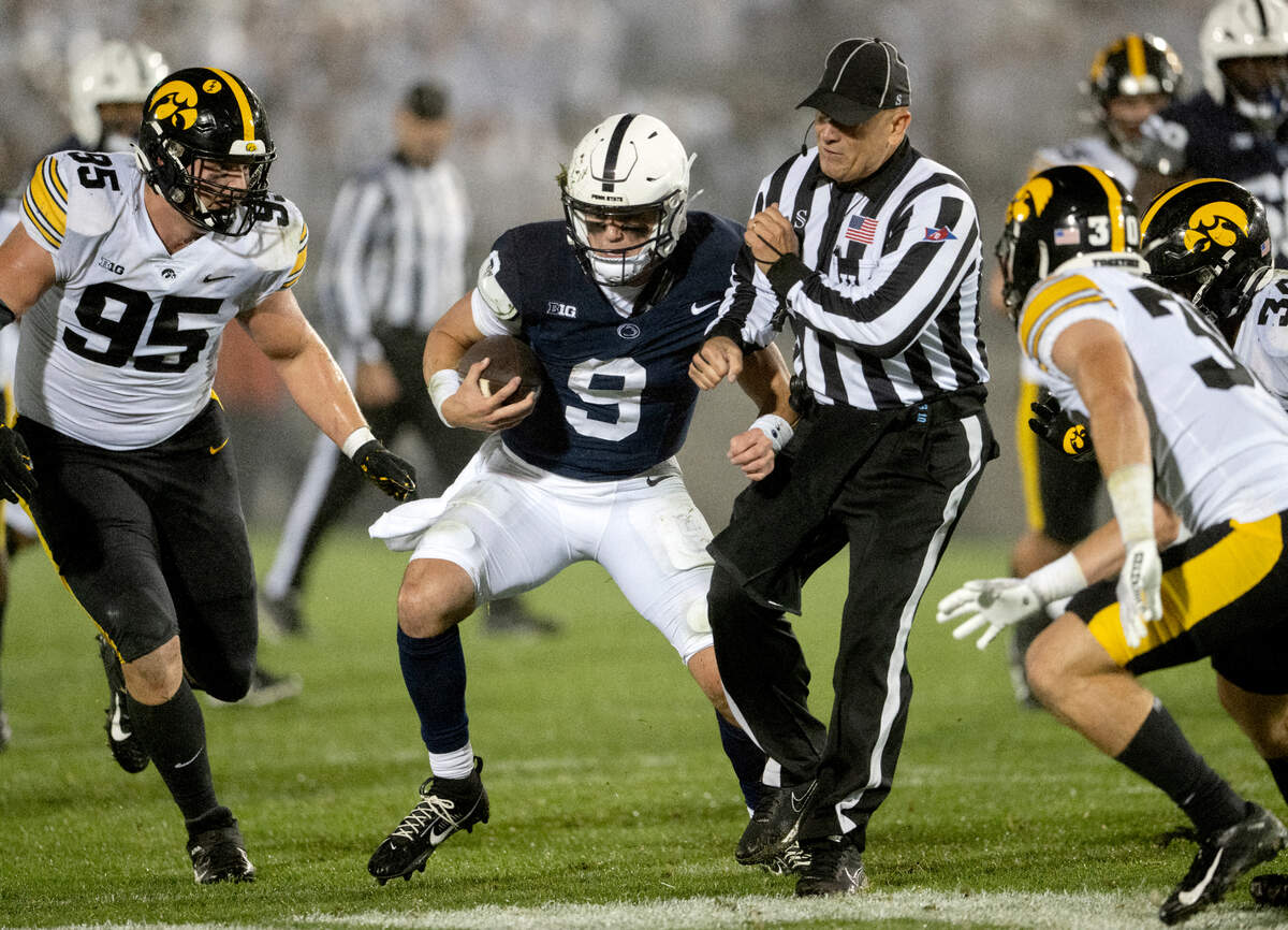 Penn State quarterback Beau Pribula cuts down the field around Iowa defenders and a referee during the game on Saturday, Sept. 23, 2023.