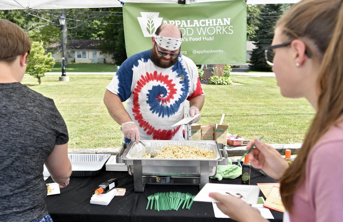 Jeremiah McClenahan from Fasta & Ravioli Co. serves up some pasta with sauce, croissant and bacon bits at the preliminary round of the Golden Basket Chef Competition at the Pine Grove Mills Farmers Market on Thursday.