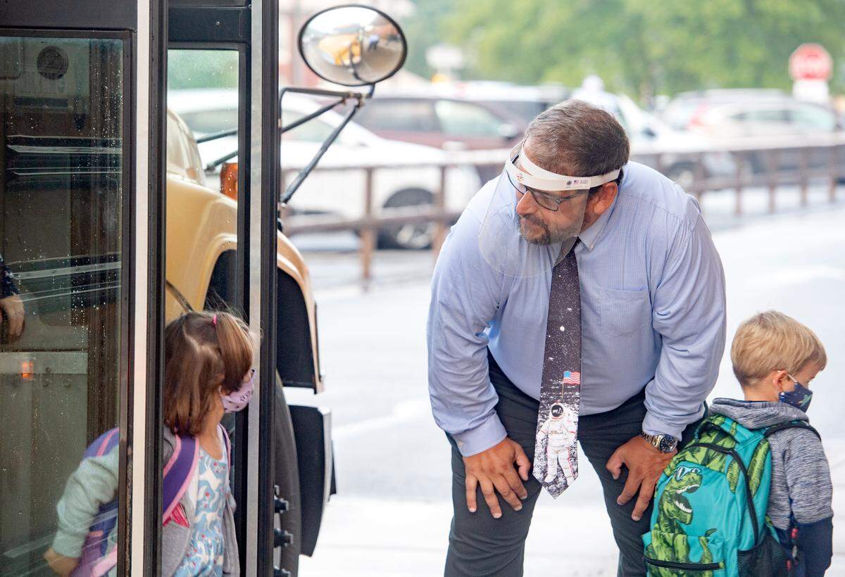 Wingate Elementary Principal James Orichosky keeps his distance and wears a face shield as he excitedly welcomes students back to school on Tuesday, Aug. 25, 2020. Orichosky said teachers and staff are ready to have fun and reconnect with the students.