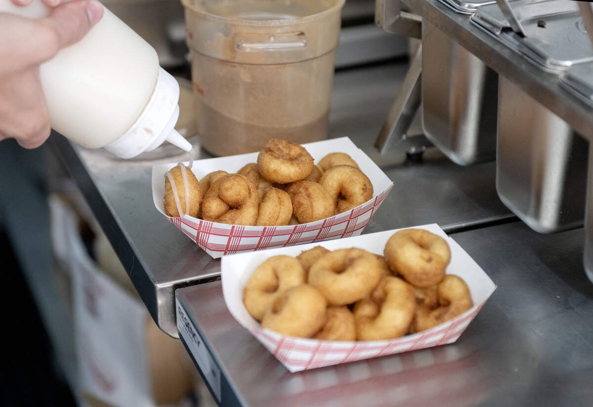 Gavin Guenot of Snowcap Sweets: By Mountaintop Concessions tops orders of mini doughnuts on Thursday, July 9, 2026.