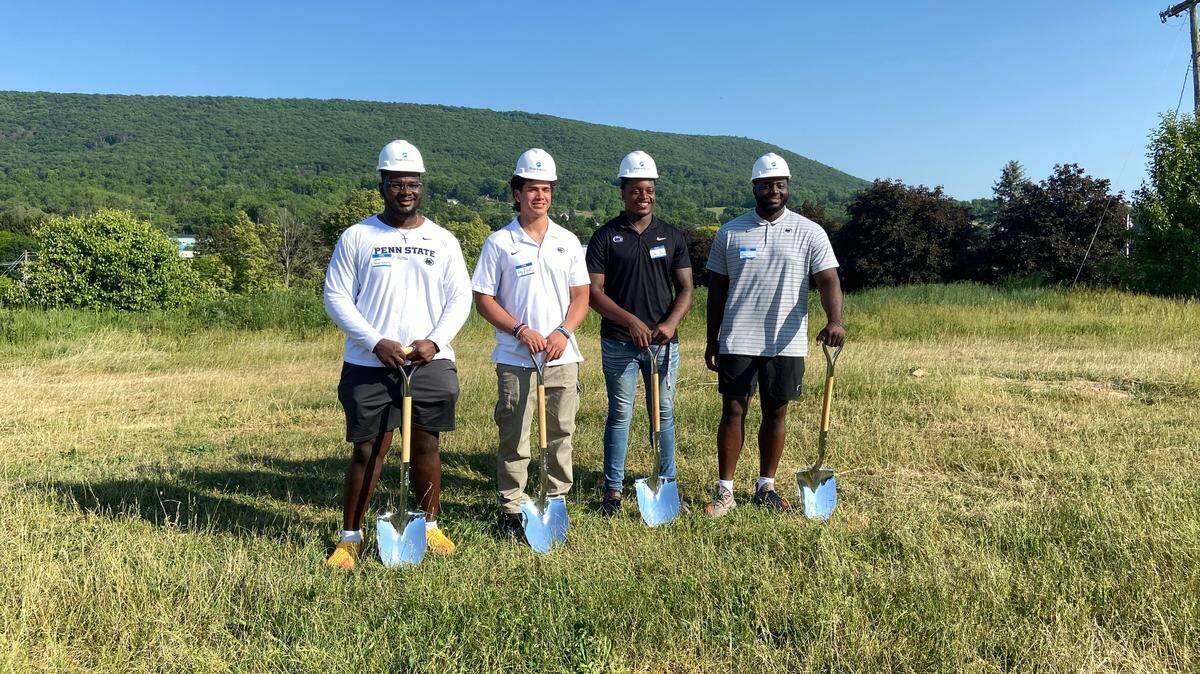 Penn State football players Golden Israel-Achumba, Tony Rojas, Ta’Mere Robinson and Ibrahim Traore participate in a groundbreaking ceremony Thursday for the State College Food Bank’s new location.