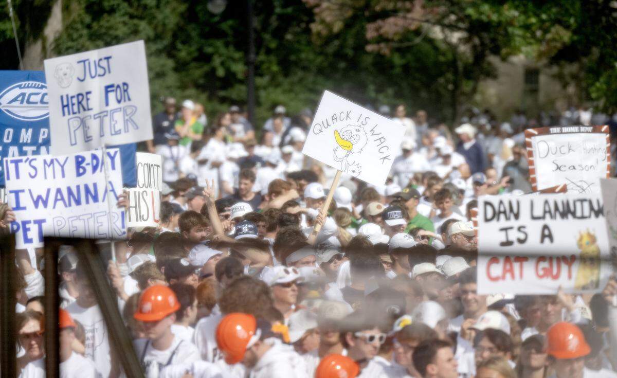 Fans hold up signs behind ESPN’s College GameDay set as it films at Penn State on Saturday, Sept. 27, 2025.  