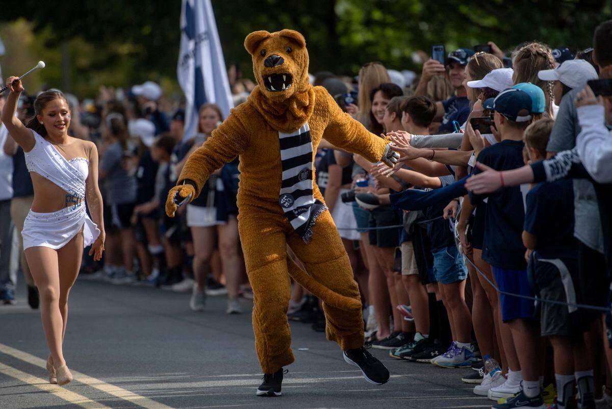 The Penn State Nittany Lion high fives fans as the football team arrives at Beaver Stadium for the home opener against Ohio on Saturday, Sept. 10, 2022.