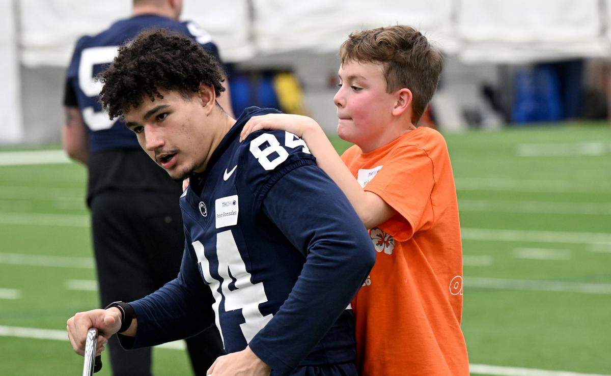 Penn State wide receiver Peter Gonzalez gives a tricycle ride to Mikey Ducker, 8, during the Thon Explorers event at in Holuba Hall on Saturday, Feb. 21, 2026.  