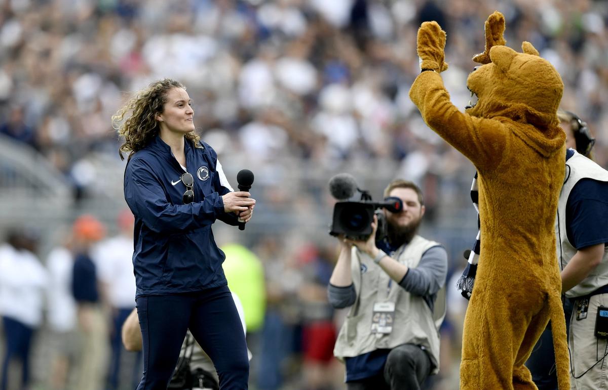 Penn State Lady Lions basketball coach Carolyn Kieger goes to high five the Nittany Lion after being introduced at the Penn State Blue and White football game on Saturday, April 13, 2019.