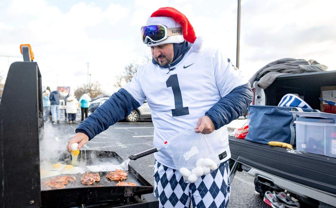 Sam Patterson cooks eggs and more for friends and family at their tailgate outside of Beaver Stadium before the CFP first round game between Penn State and SMU on Saturday, Dec. 21, 2024.