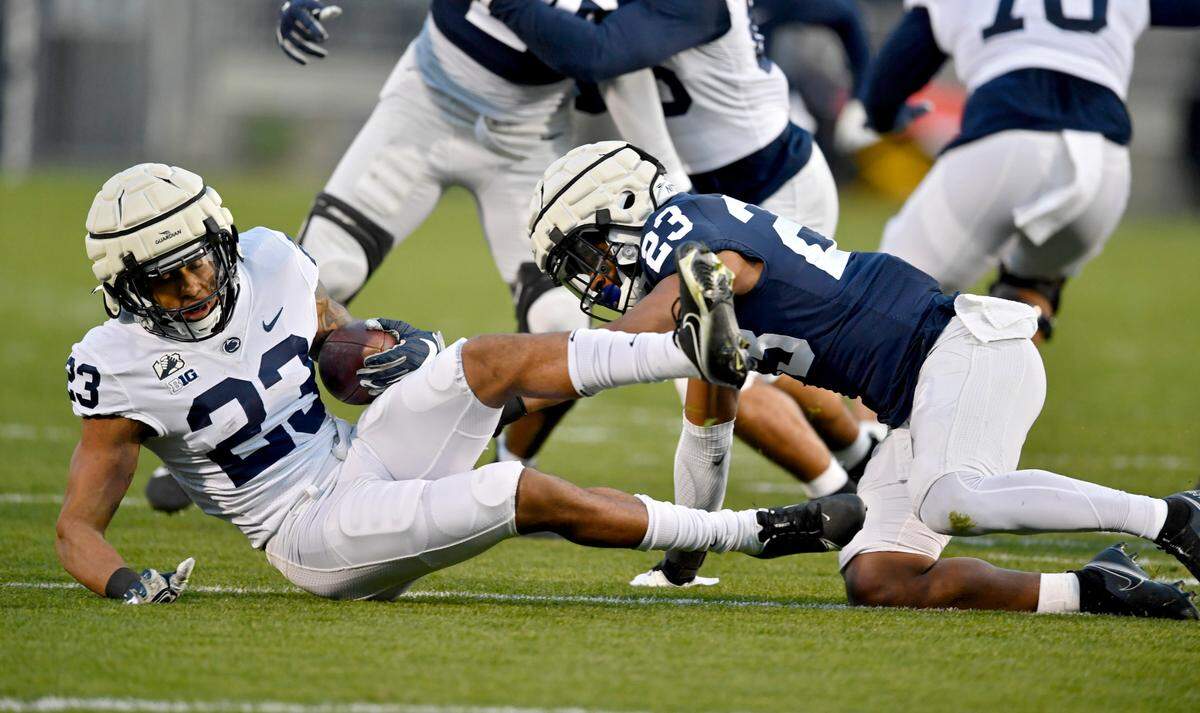 Linebacker Curtis Jacobs trips up running back John Lovett during Penn State football practice on Friday, April 23, 2021 at Beaver Stadium.