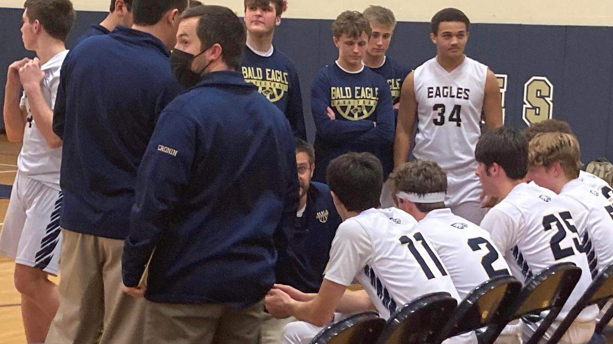 Bald Eagle Area’s basketball team huddles during a timeout Thursday night. The Eagles were clipped by Huntingdon 60-56 at home.