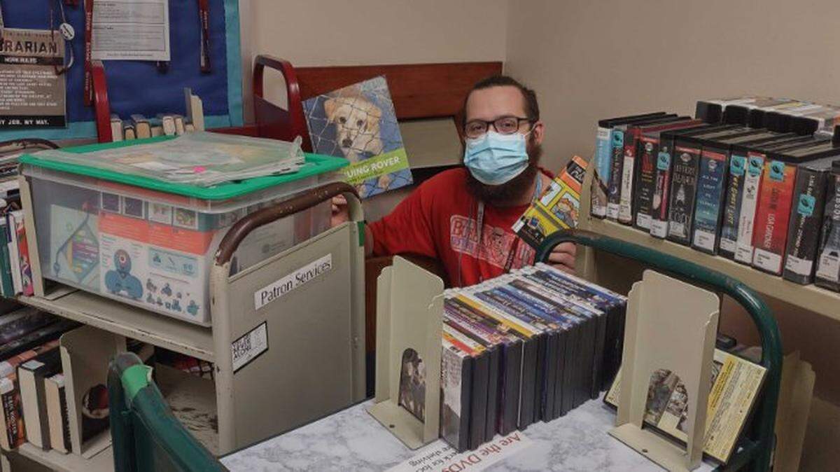 Ed Lambert, a page at Schlow Centre Region Library, checks for lost items in the book drop recently.