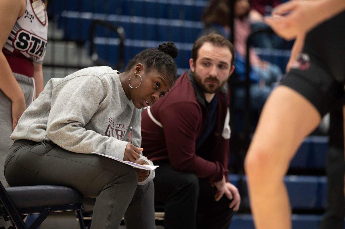 State High girls wrestling coach Eshia Willingham writes down notes during a junior high girls wrestling bout at Rec Hall on Tuesday, Dec. 17, 2024.