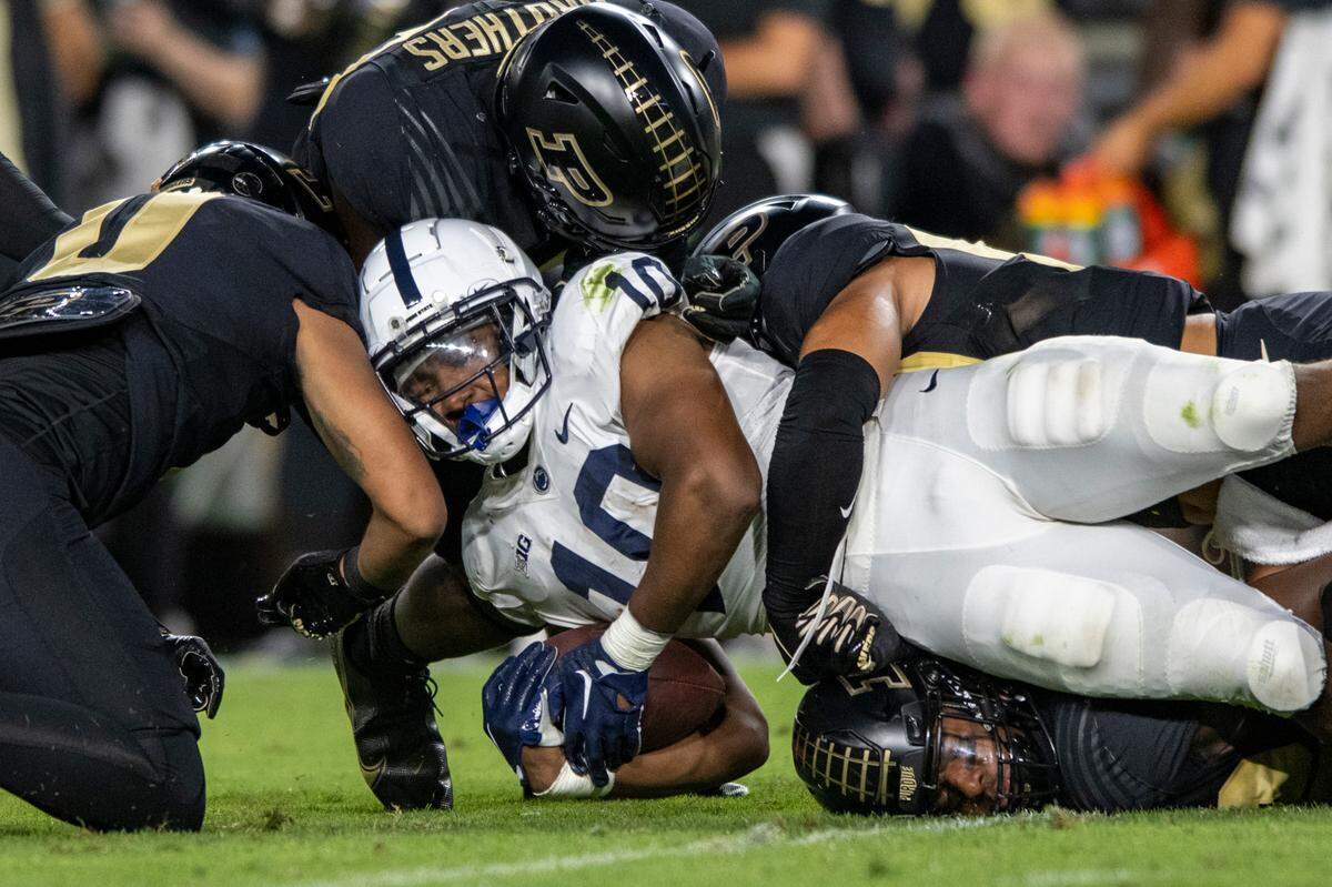 Penn State running back Nicholas Singleton (10) is tackled by Purdue defenders during the game Sept. 1, 2022, in West Lafayette, Ind.