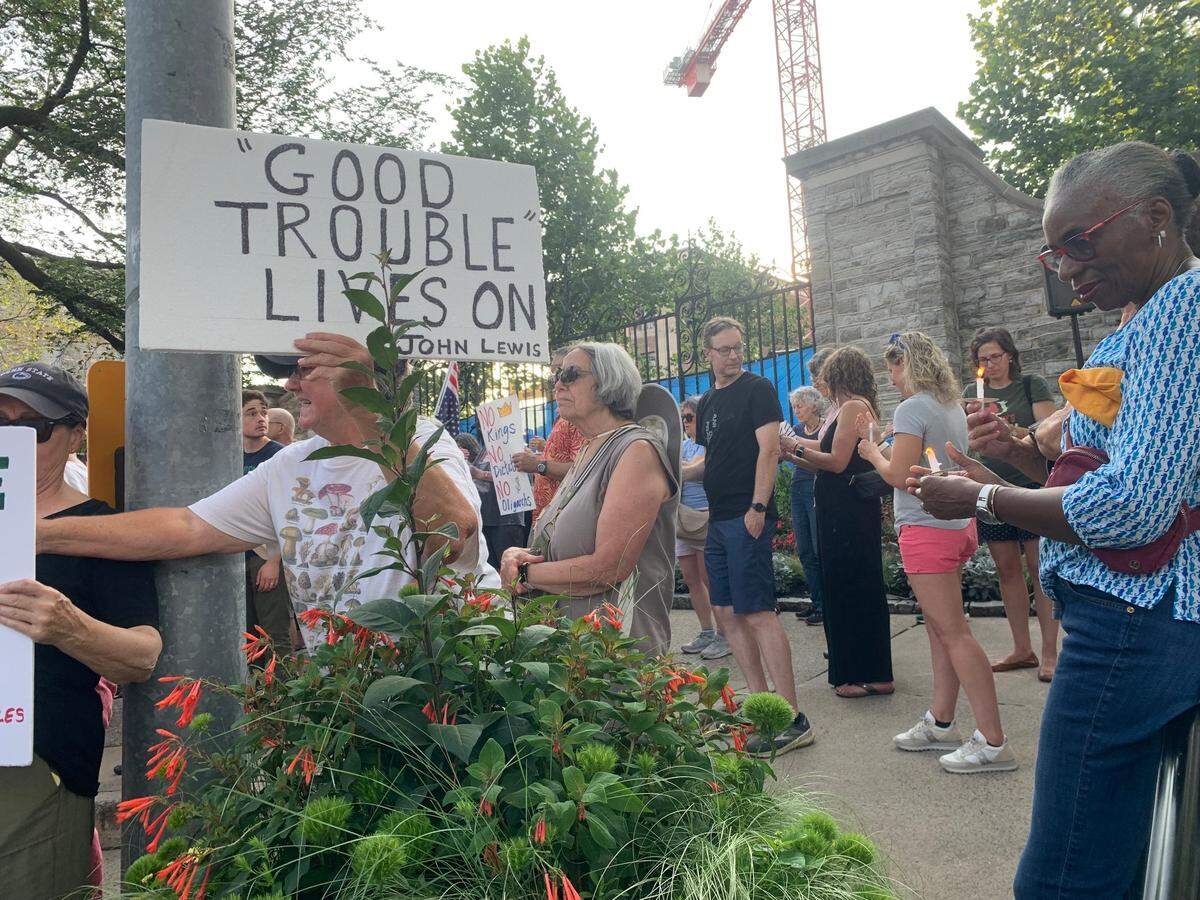 A demonstrator holds “Good Trouble” sign, a term coined by the late civil rights activist John Lewis during a rally on Thursday, July 17, 2025.