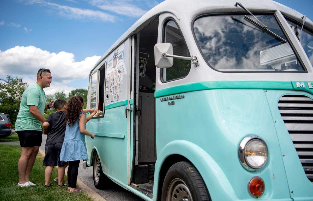 A family eagerly orders ice cream from the Classic Cones ice cream truck on Friday, June 3, 2022.