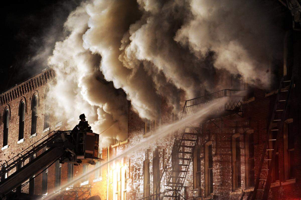 A fireman sprays water on the blaze inside the Do De Hotel building, along East High Street, in Bellefonte in 2012.