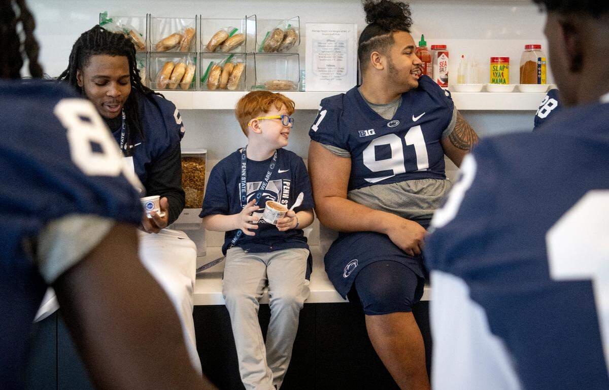 Owen Bonn, 9, sits among between Hakeem Beamon and Dvon Ellies to enjoy some ice cream during the Thon Explorers program at the Lasch Building on Saturday, Feb. 18, 2023.