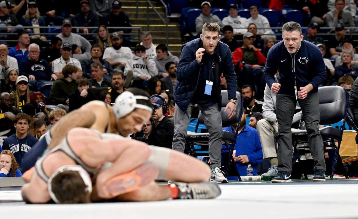 Penn State wrestling coaches Nick Lee and Cody Sanderson yell to Shayne Van Ness during his 149-pound championship bout of the Big Ten Wrestling Championships on Sunday, March 8, 2026.  