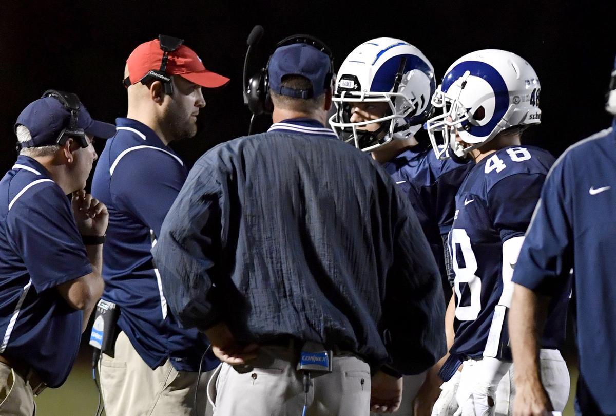 Penns Valley coaches Rob Irwin and Martin Tobias talk with quarterback Aaron Tobias and running back Colton Winkelblech during the game against Bald Eagle Area on Friday, Sept. 6, 2019.