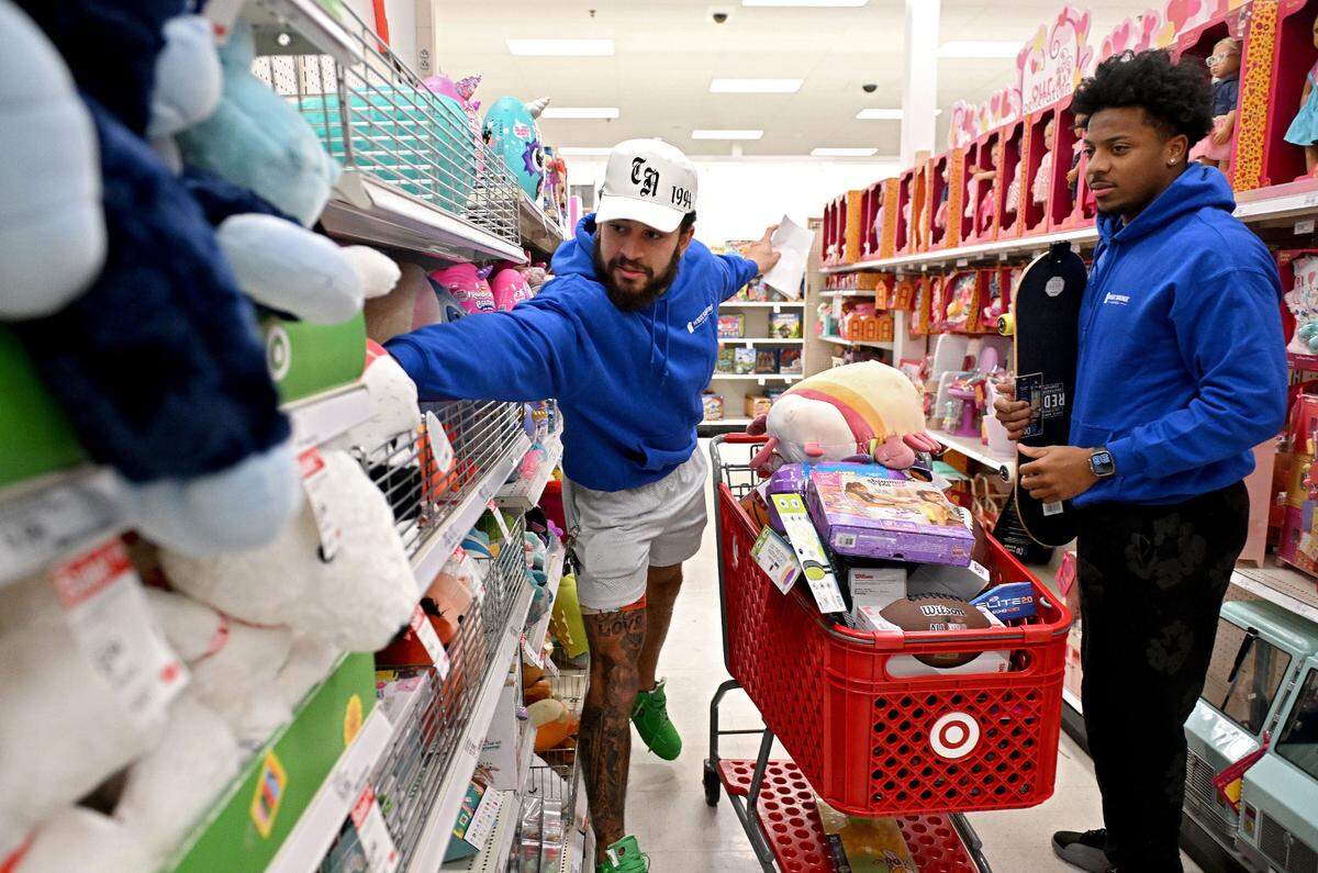 Penn State wide receiver Julian Fleming reaches for some squishmallows with teammate DaKarri Nelson as they help West Shore Home shop for Toys for Tots on Monday, Dec. 2, 2024 at Target.