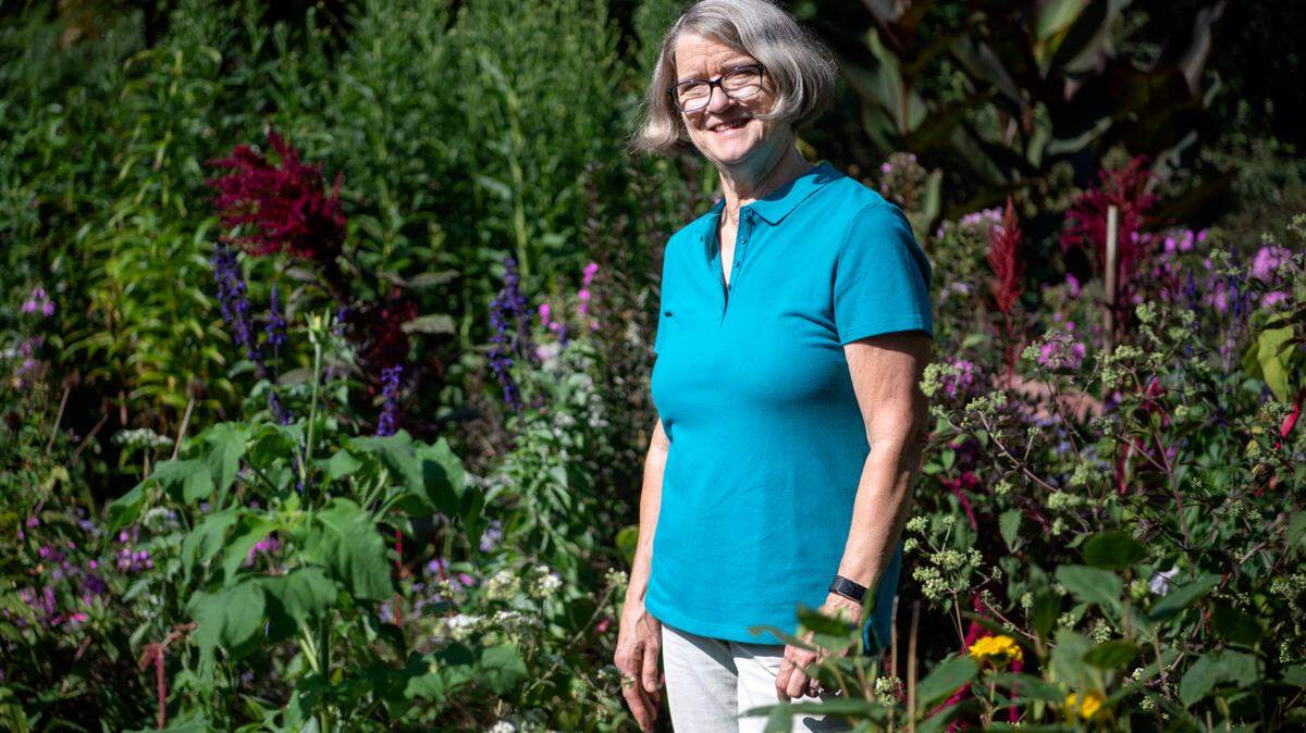 Joyce Christini, the longest-standing Centre County member of the Penn State Master Gardener program, poses Thursday in her garden in front of her home in State College.