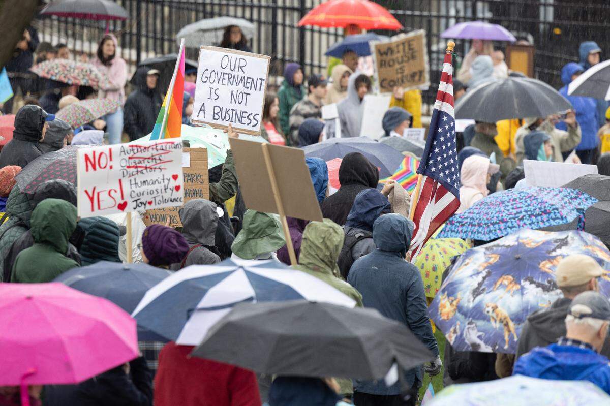 Protesters hold signs Saturday while listening to speakers at the “Hands Off!” rally at State College’s Sidney Friedman Park, in opposition of President Donald Trump. The event was part of a nationwide effort that saw more than 1,000 similar rallies held across all 50 states.