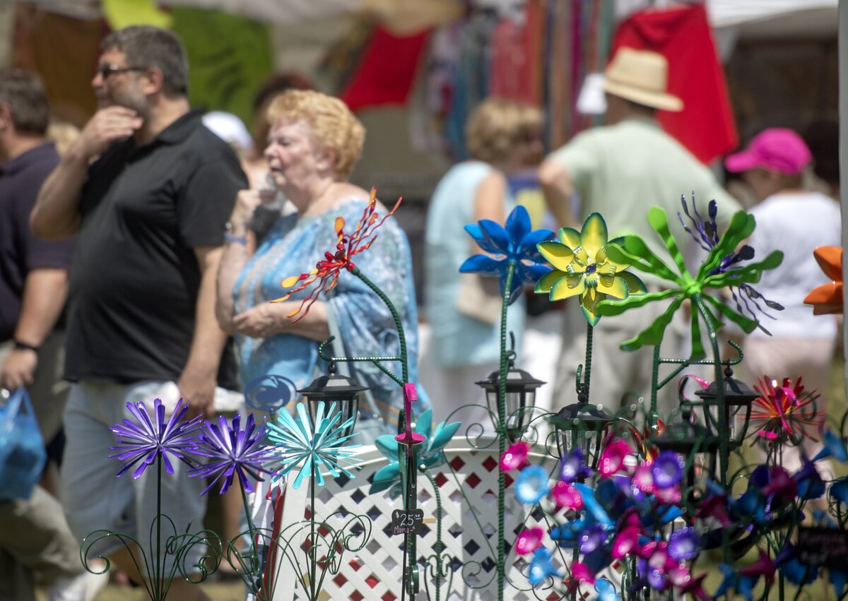 Visitors walk by the art at the People’s Choice Festival of Pennsylvania Arts & Crafts at the Pennsylvania Military Museum in Boalsburg on Friday, July 12, 2019.