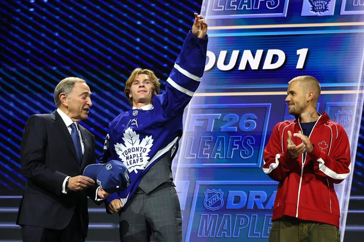 BUFFALO, NEW YORK - JUNE 26: (L-R) NHL commissioner Gary Bettman hands Gavin McKenna of Canada hat as singer Justin Bieber looks on after McKenna was drafted by the Toronto Maple Leafs with the first overall pick during day one of the 2026 NHL Draft on June 26, 2026 in Buffalo, New York. (Photo by Bruce Bennett/Getty Images)