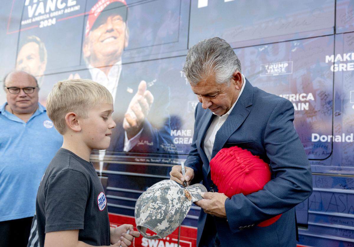 Abel Maldonado, former lieutenant governor of California, signs a hat during a stop of the “Team Trump” bus tour on Tuesday, Oct. 22, 2024.