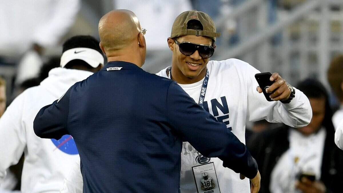 Penn State commit Brandon Smith, a five-star linebacker, greets Penn State football coach James Franklin on the field before the Nittany Lions’ game against Ohio State on Sept. 29.
