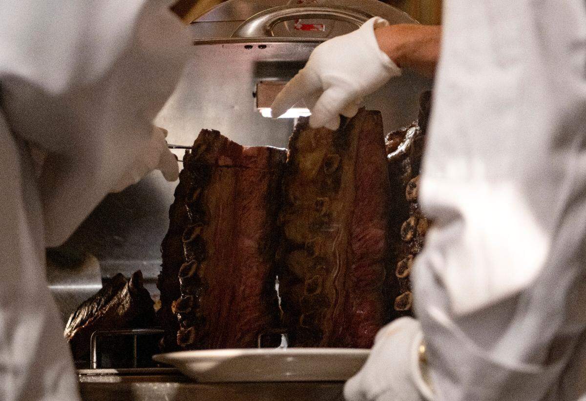 Penn State defensive tackle PJ Mustipher does the ceremonial first cut of prime rib at the Lawry’s Beef Bowl on Friday, Dec. 30, 2022.