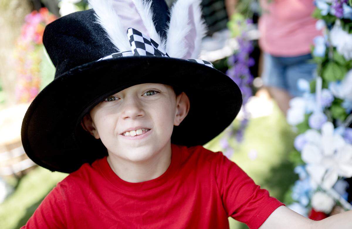 Karrter Walter smiles for a photo wearing a top hat as he and his family prepare their Alice in Wonderland themed tent at the Centre County Grange Fair on Friday, Aug. 15, 2025. Karrter said his favorite fair food is pizza.