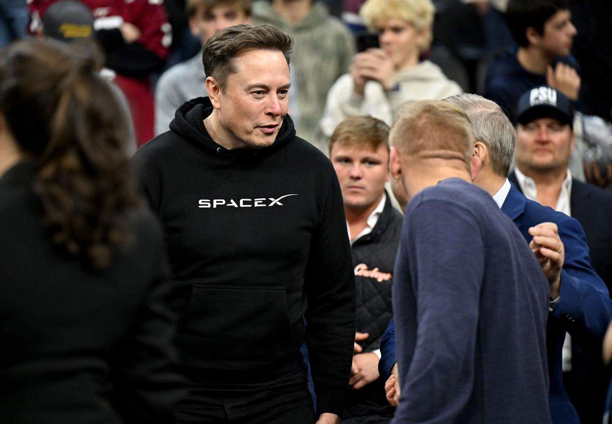 Elon Must meets wrestler Kyle Dake at the 2025 NCAA Wrestling Championships at the Wells Fargo Center in Philadelphia on Saturday March 22, 2025.