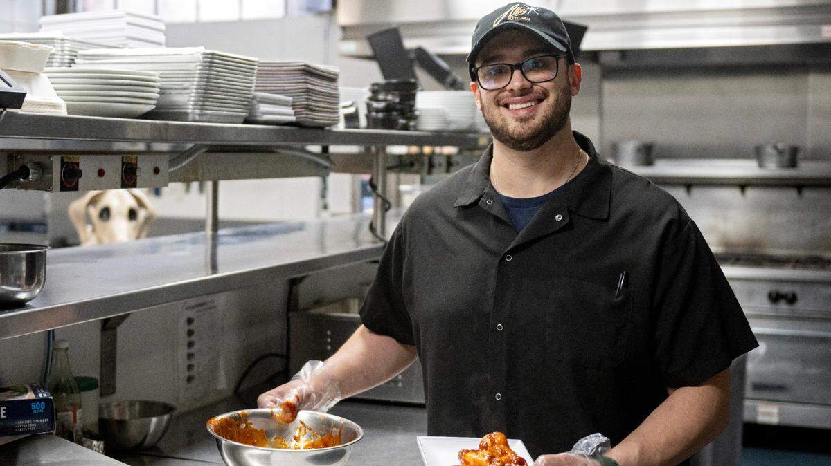 Tony Caracillo, the new owner of Alloy Kitchen, holds an order of Nelly’s Jumbo Sweet and Spicy wings on Thursday, April 10, 2025.