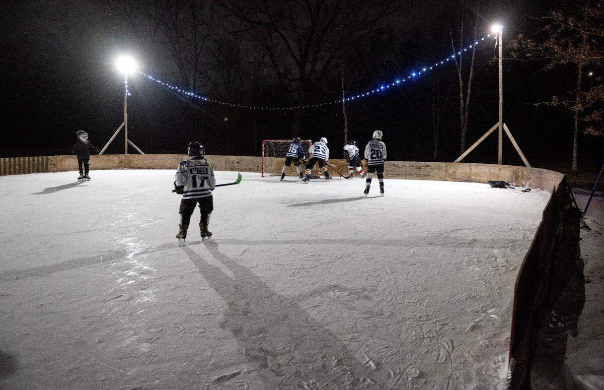 Friends enjoy the ice rink in Bill Dickson’s backyard in Lemont on Thursday, Feb. 20, 2025.