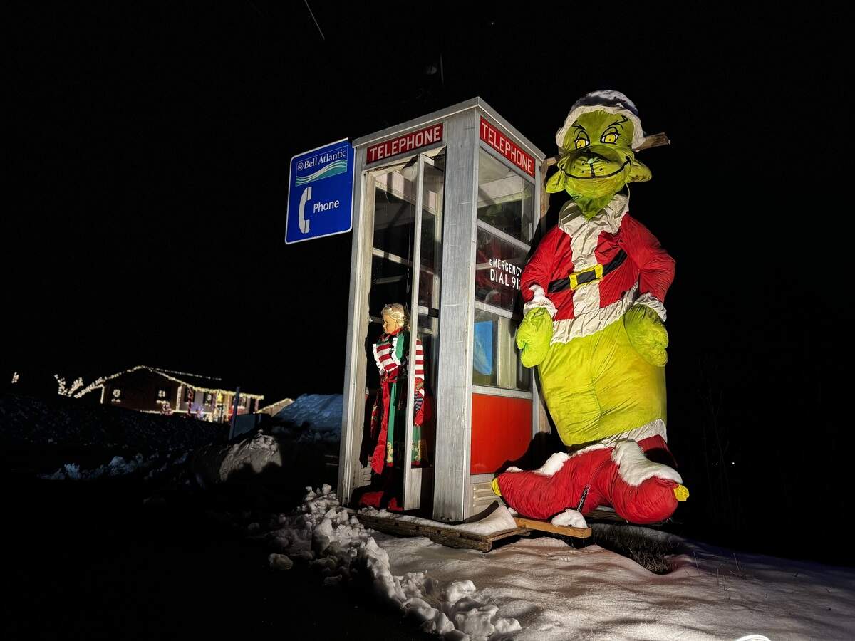 A stuffed Grinch inflatable stands next to an old phone booth at 510 Flat Rock Road, Port Matilda on Dec. 3, 2025.