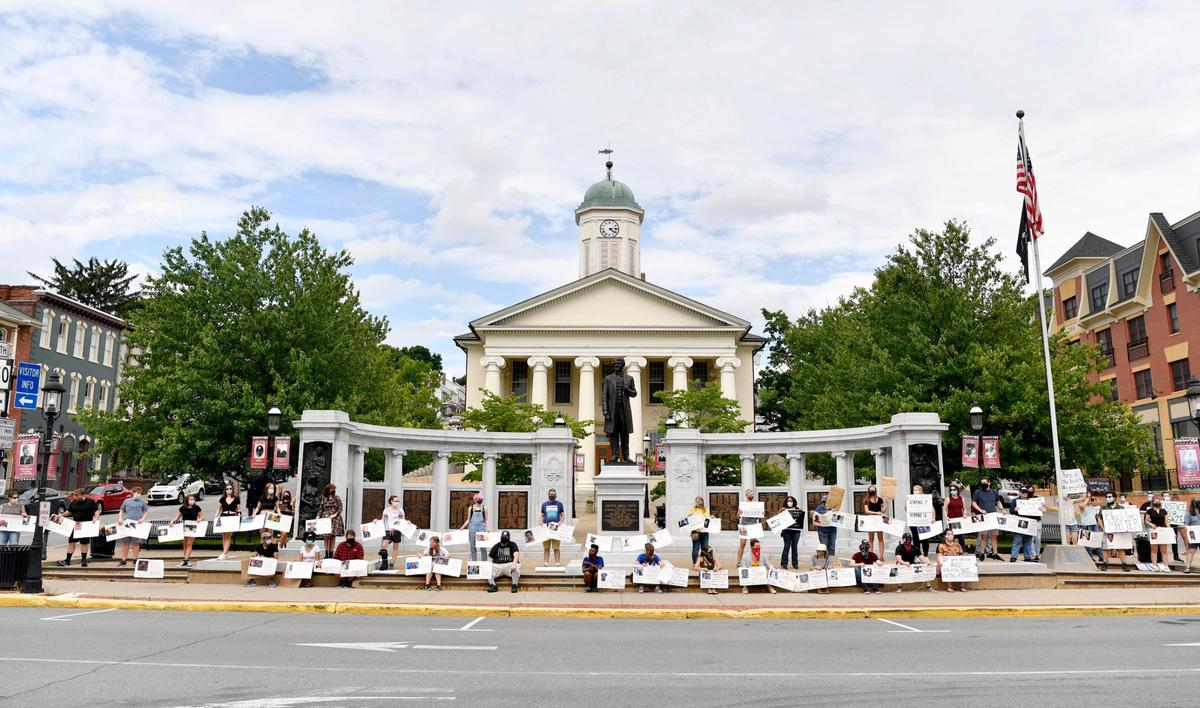 Community members gather outside of the Centre County Courthouse in Bellefonte on Tuesday in a protest organized by the 3/20 Coalition.