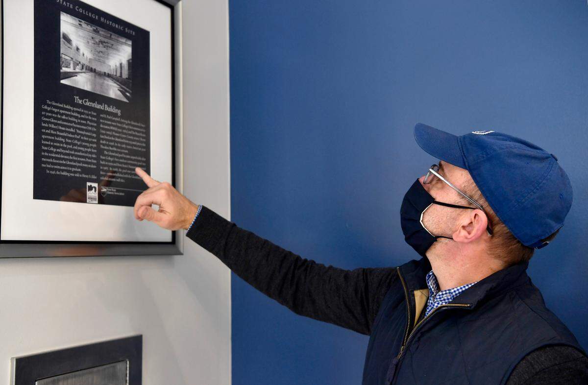 Gary Brandeis, president of Scholar Hotel Group, shows the copy of the historic sign with information about the Glennland Building Thursday in the Scholar Hotel State College.