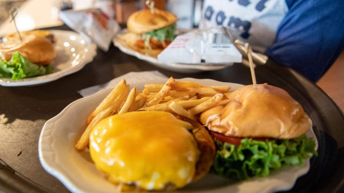 A burger and fries and several other meals are delivered to diners at The Corner Room on Thursday. The downtown State College staple debuted a new menu this summer.
