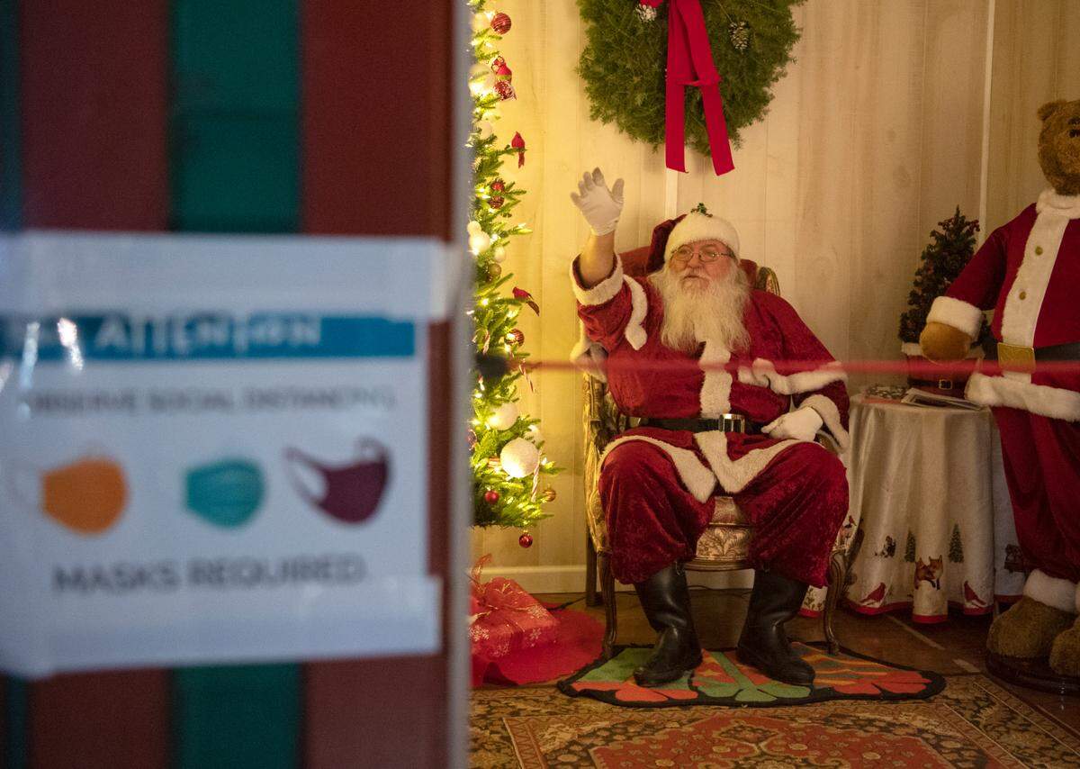 Santa waves to cars from his house in front of the Centre County courthouse on Tuesday, Dec. 15, 2020.