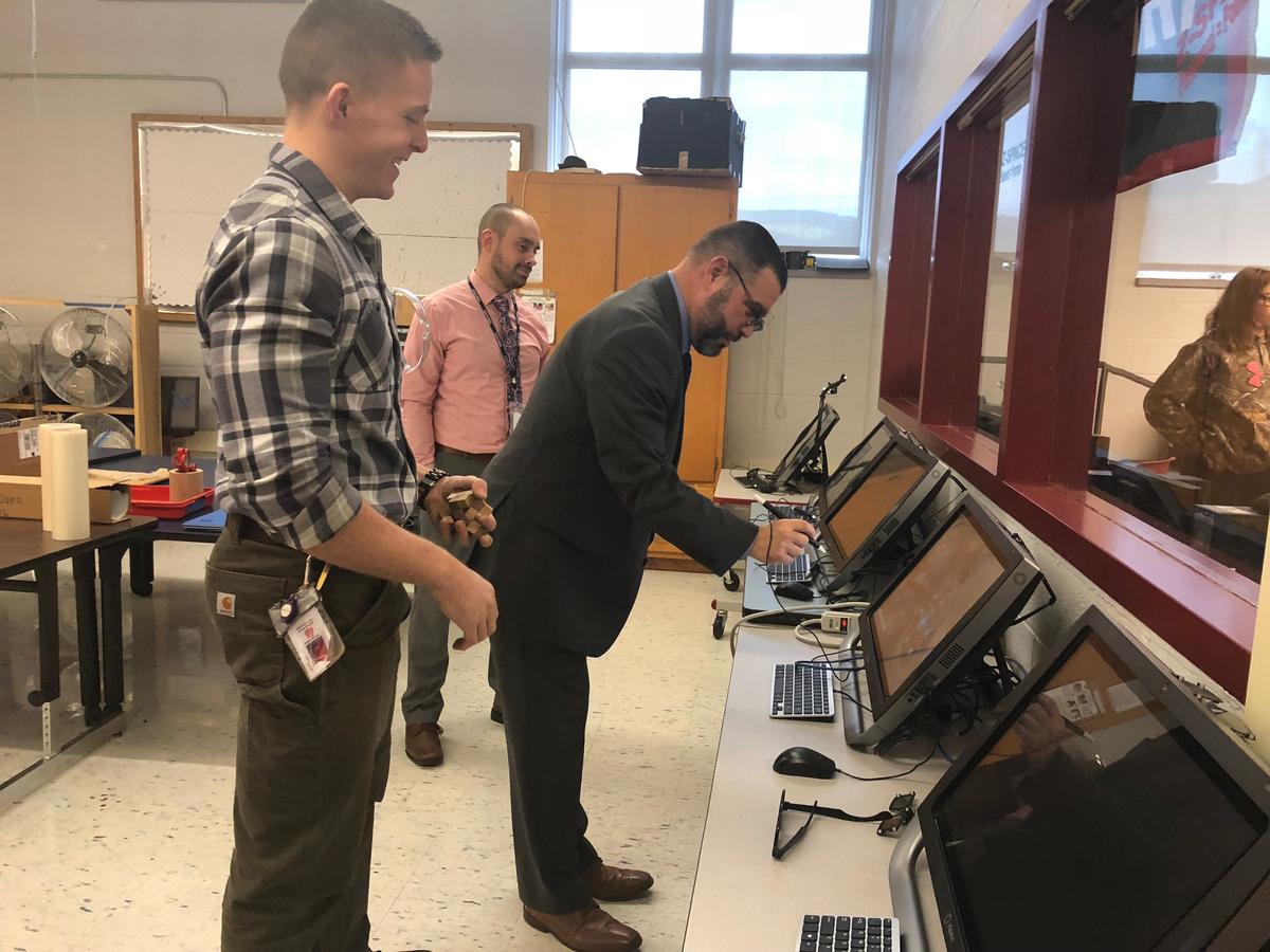 Secretary of Education Pedro Rivera tries out a zSpace virtual reality computer as teacher Jordan Eccher looks on at Bellefonte Area Middle School on Thursday, Oct. 25, 2018.
