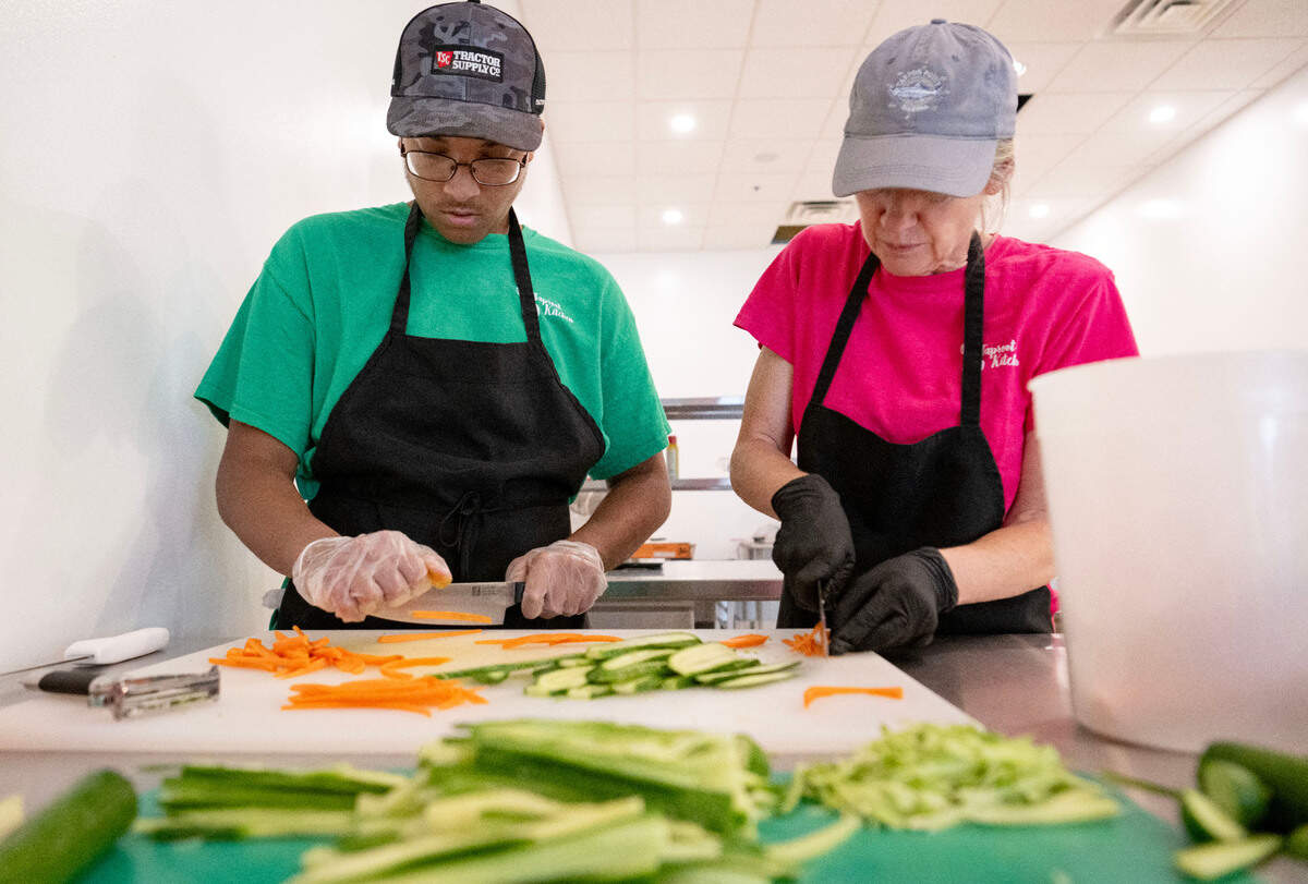 William Francis and Sharon Schafer slice carrots and cucumbers to make veggie wraps at Taproot Kitchen on Thursday, August 1, 2024.