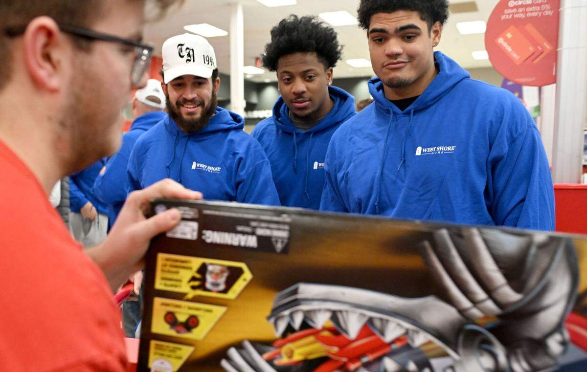 Penn State football players Julian Fleming, DaKarri Nelson, and Drew Shelton watch as the toys they picked out for Toys for Tots are scanned at the checkout at Target on Monday, Dec. 2, 2024.