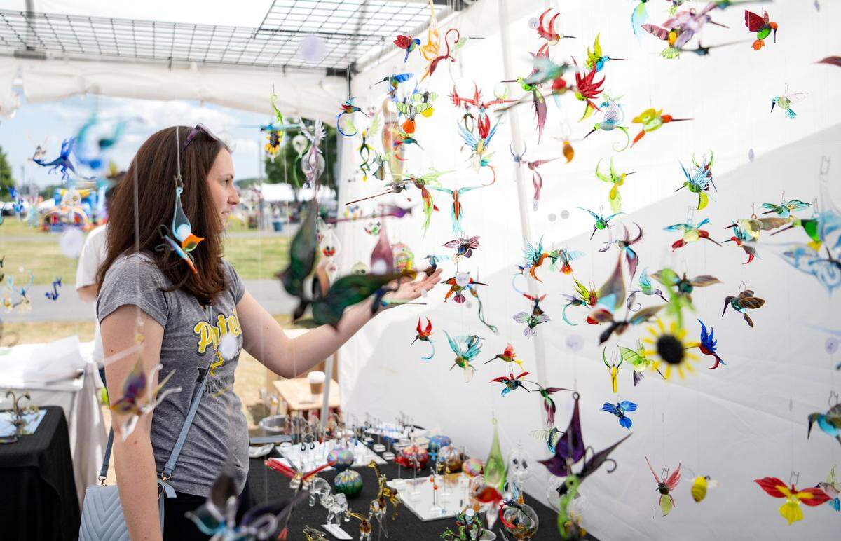 Visitors browse the WGK Glass Art, Inc. booth at the People’s Choice Festival of Pennsylvania Arts & Crafts at the Centre County Grange Fairgrounds on Friday, July 15, 2022.