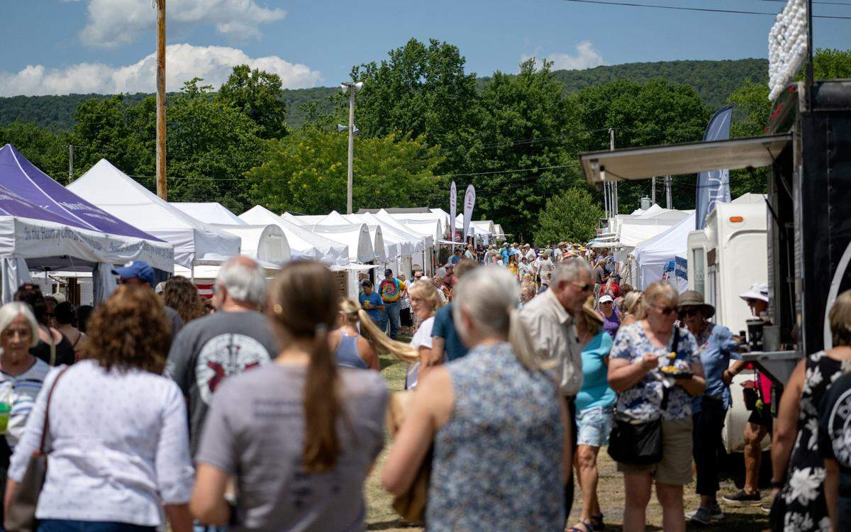 Visitors browse the artisans at the People’s Choice Festival of Pennsylvania Arts & Crafts at the Centre County Grange Fairgrounds on Friday, July 15, 2022.