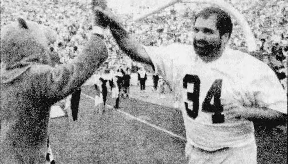 Harris greets the Nittany Lion mascot during a halftime ceremony in 1994 held to honor the 1968 and 1969 Penn Stae football teams.