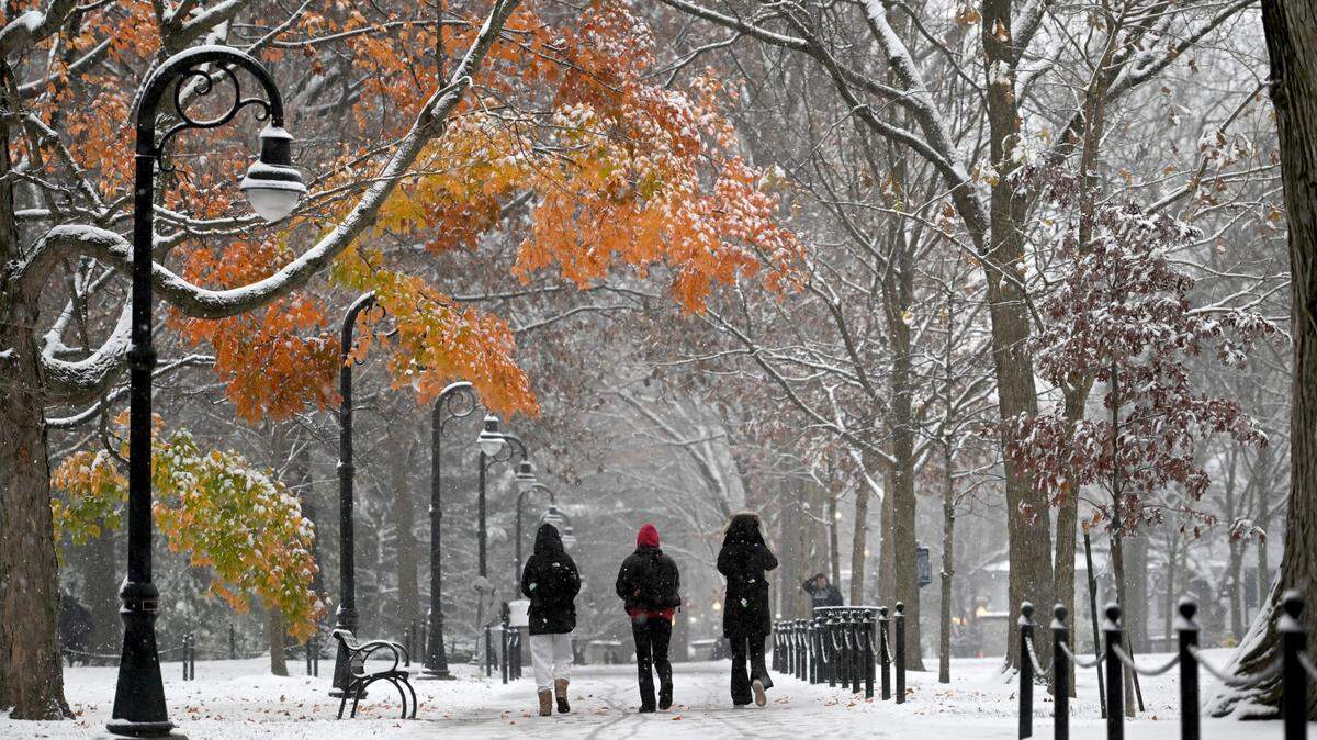 Snow coats the trees as students walk along the Allen Street mall on the Penn State campus Tuesday, Nov. 15, 2022. The National Weather Service State College office forecasts a 50% to 70% chance of rain this New Year’s weekend.