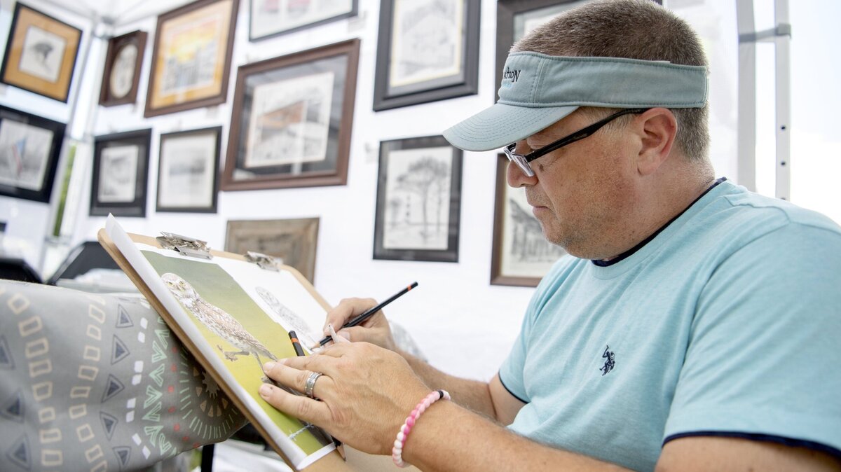 Frank LaMartina works on a piece of an owl in his booth at the People’s Choice Festival of Pennsylvania Arts & Crafts at the Pennsylvania Military Museum in Boalsburg on Friday, July 12, 2019.  LaMartina, from Red Lion, does all graphite and color pencil drawings.