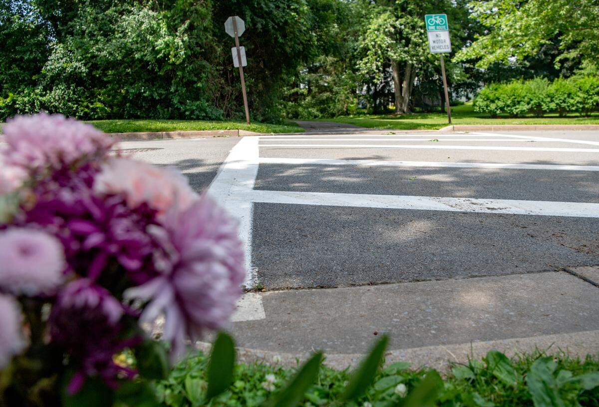 Flowers and a candle sit next to the bike path where it crosses Edgewood Circle on Thursday, June 16, 2022.