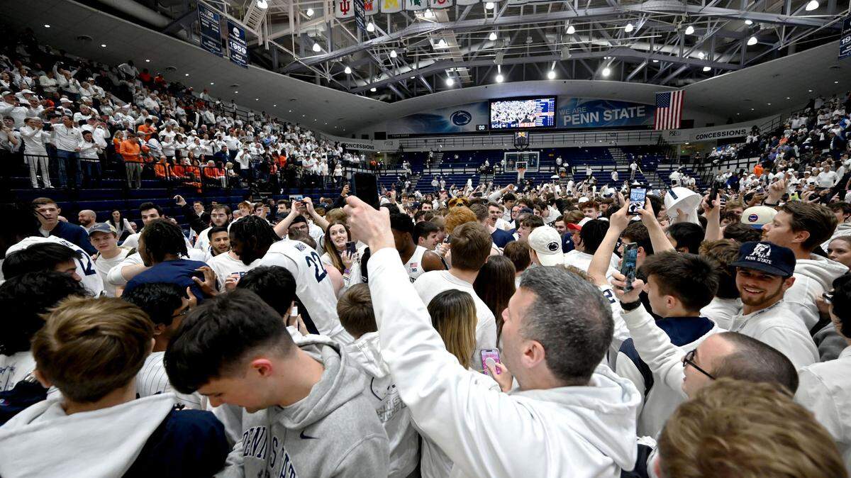 Penn State fans rush the court to celebrate the men’s basketball win over Illinois on Wednesday at Rec Hall.